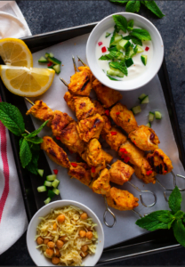 Tandoori Chicken Skewers on a tray with dip.